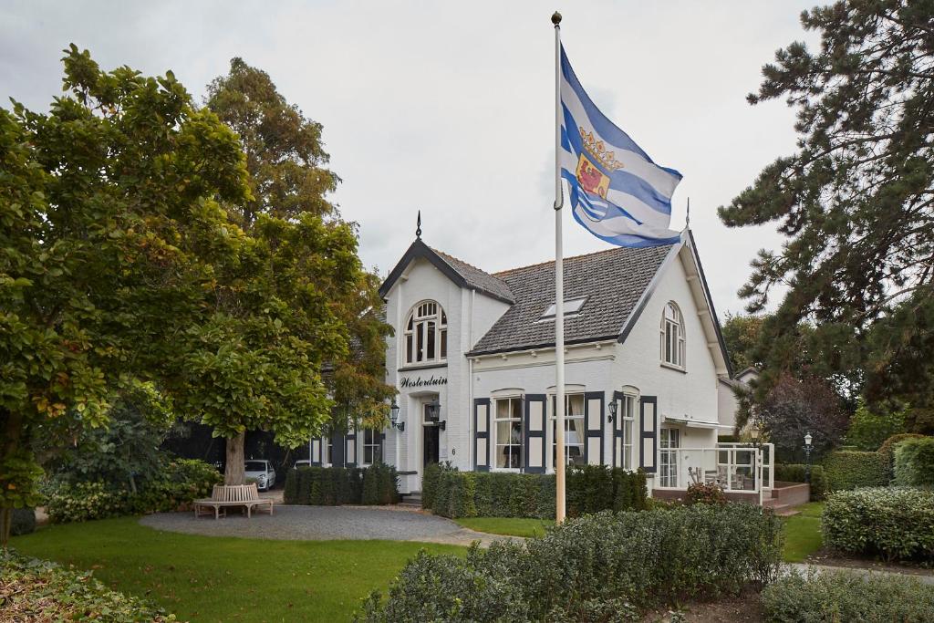 
a white house with a flag on top of it at Villa Westerduin in Renesse

