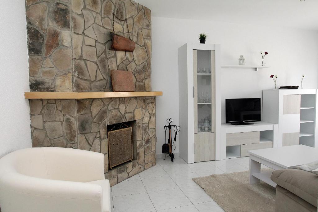sala de estar con chimenea de piedra en Apartamento junto al Duero en la Sierra de Urbión, en Molinos de Duero