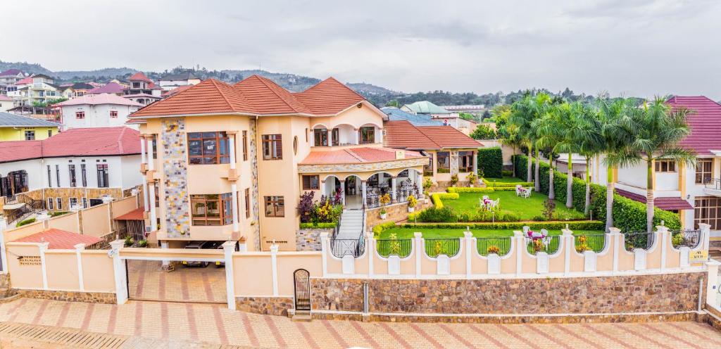 a house with a white fence in a city at Mountain's View Hotel in Bujumbura