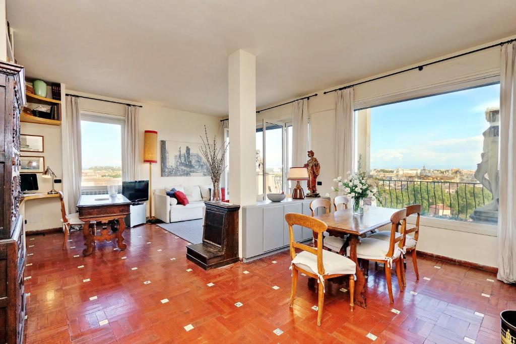 ローマにあるSant'Onofrio Terrace Apartmentのリビングルーム(テーブル、椅子、大きな窓付)