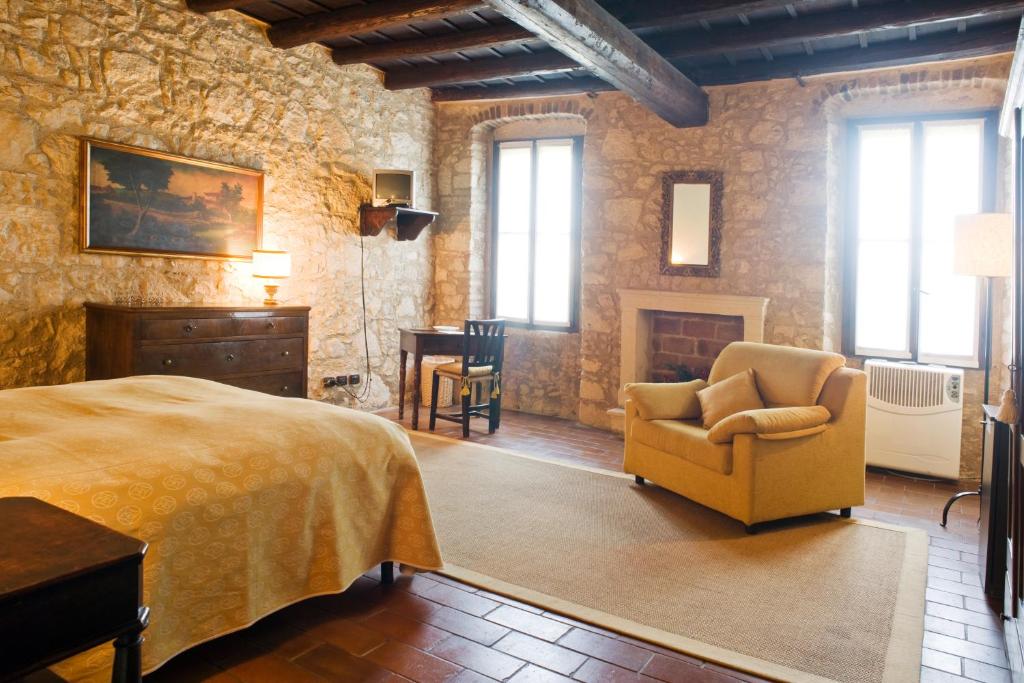 ein Schlafzimmer mit einem Bett, einem Stuhl und einem Kamin in der Unterkunft I Costanti in Caldiero