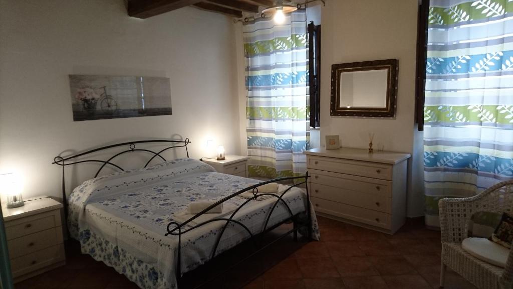 モンテプルチャーノにあるHoliday House Montepulciano - La Pianaのベッドルーム1室(ベッド1台、ドレッサー2台、鏡付)