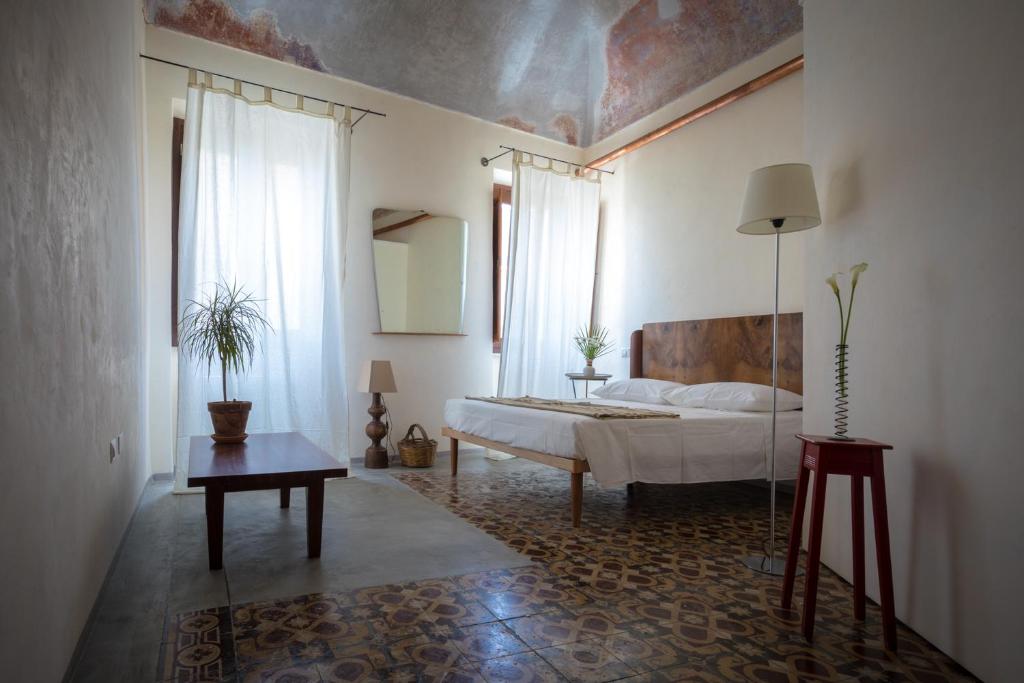 ein Schlafzimmer mit einem Bett und einem Tisch darin in der Unterkunft Piazza San Pantaleo in Sorso