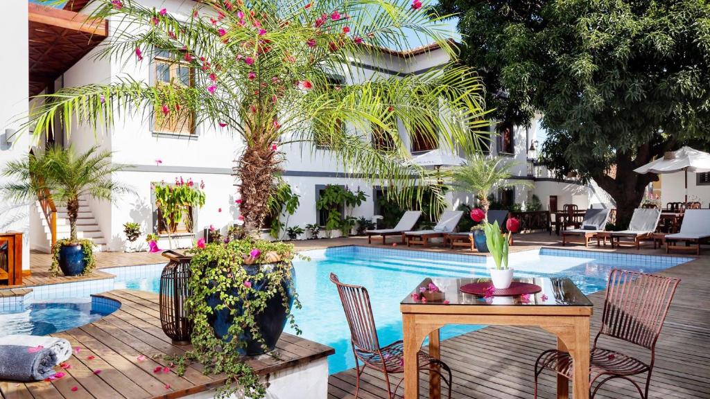 un patio con piscina, mesa y sillas en Casa de St. Antônio Hotel Boutique, en Parnaíba