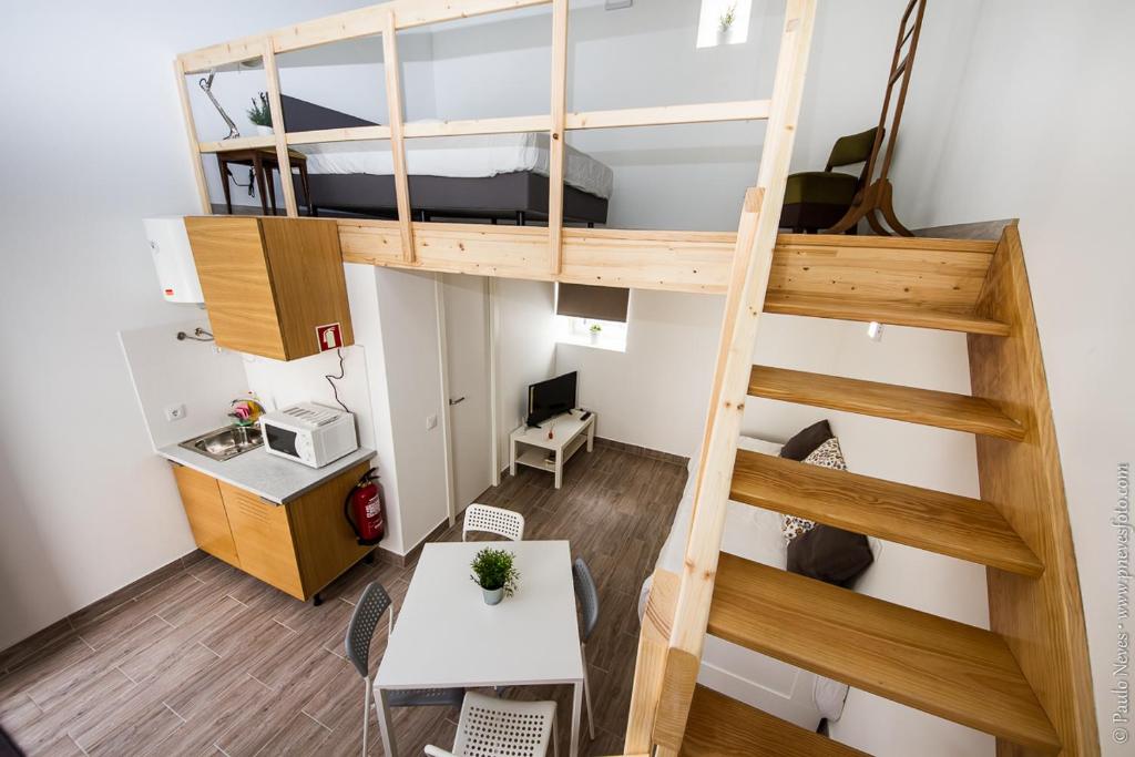 ポルトにあるIlha da Glória - Miragaiaのロフトベッド1台、デスクが備わる小さなアパートメントです。