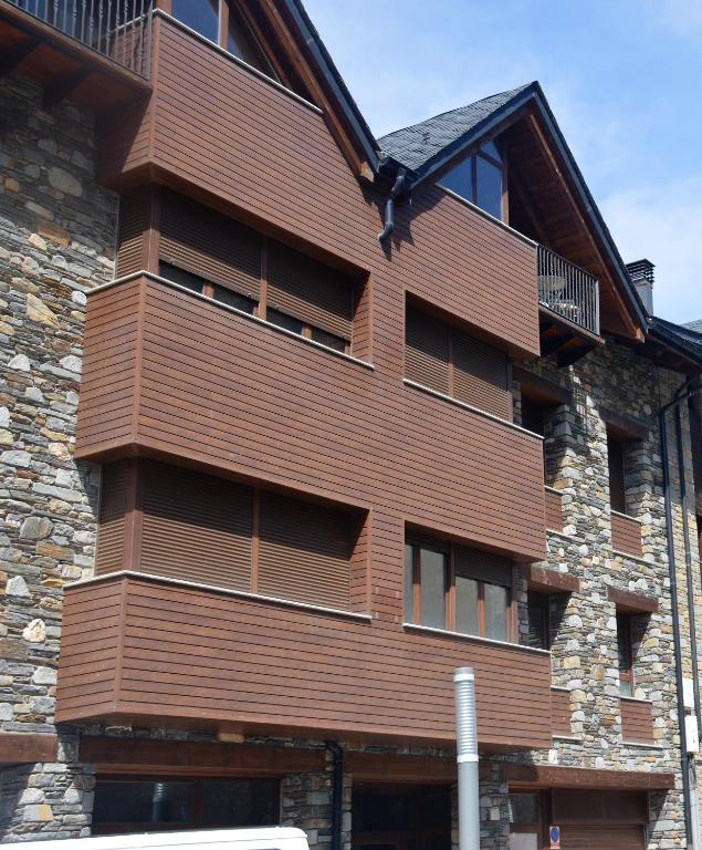 a building with a wooden facade with windows at Apartament Esterri Centre in Esterri d'Àneu