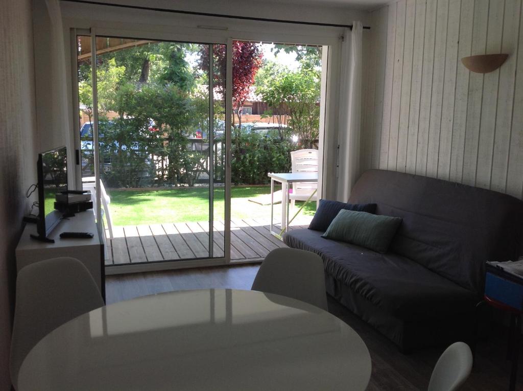 a living room with a couch and a sliding glass door at Appart & p'tit Jardin in Arès