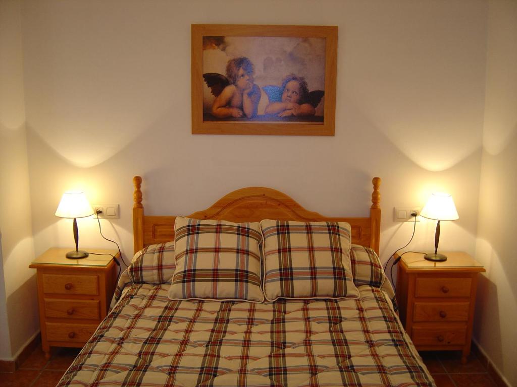 アロヨ・フリオにあるCasa Antoniaのベッドルーム1室(ナイトスタンド2つ、ランプ2つ付)