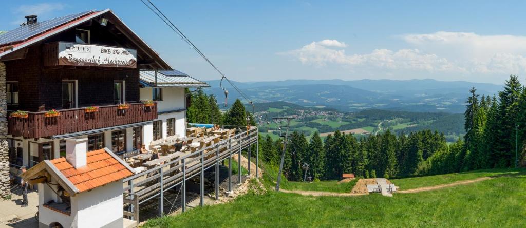 un bâtiment situé sur le côté d'une colline avec vue dans l'établissement Berggasthof Hochpröller, à Sankt Englmar