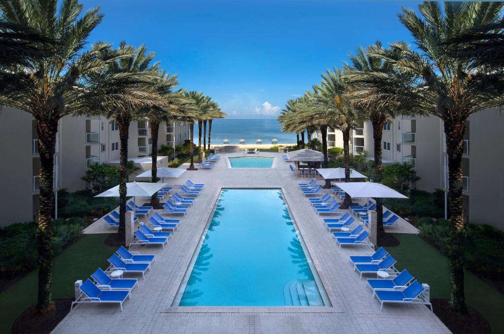 an infinity pool with lounge chairs and palm trees at Edgewater Beach Hotel in Naples