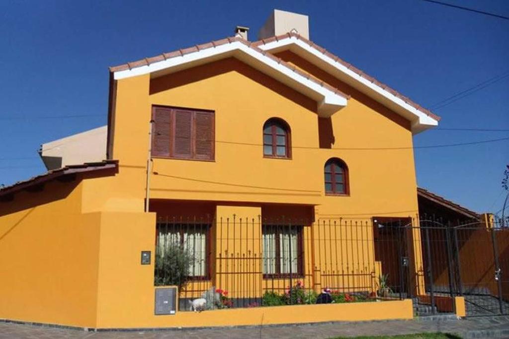 una casa amarilla con una valla delante de ella en Casa en B° Tres Cerritos, Salta Capital. Alquiler Temporal en Salta