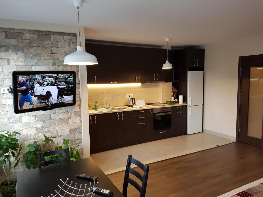 a kitchen with a tv hanging on a brick wall at Apartments Sofia Yavorov in Sofia