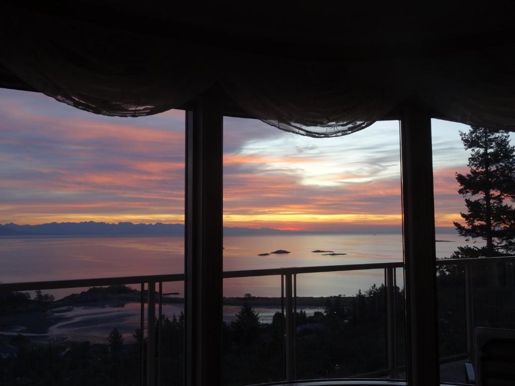 a view of a sunset from a bedroom window at Gibralter Rock Ocean View B&B in Nanaimo