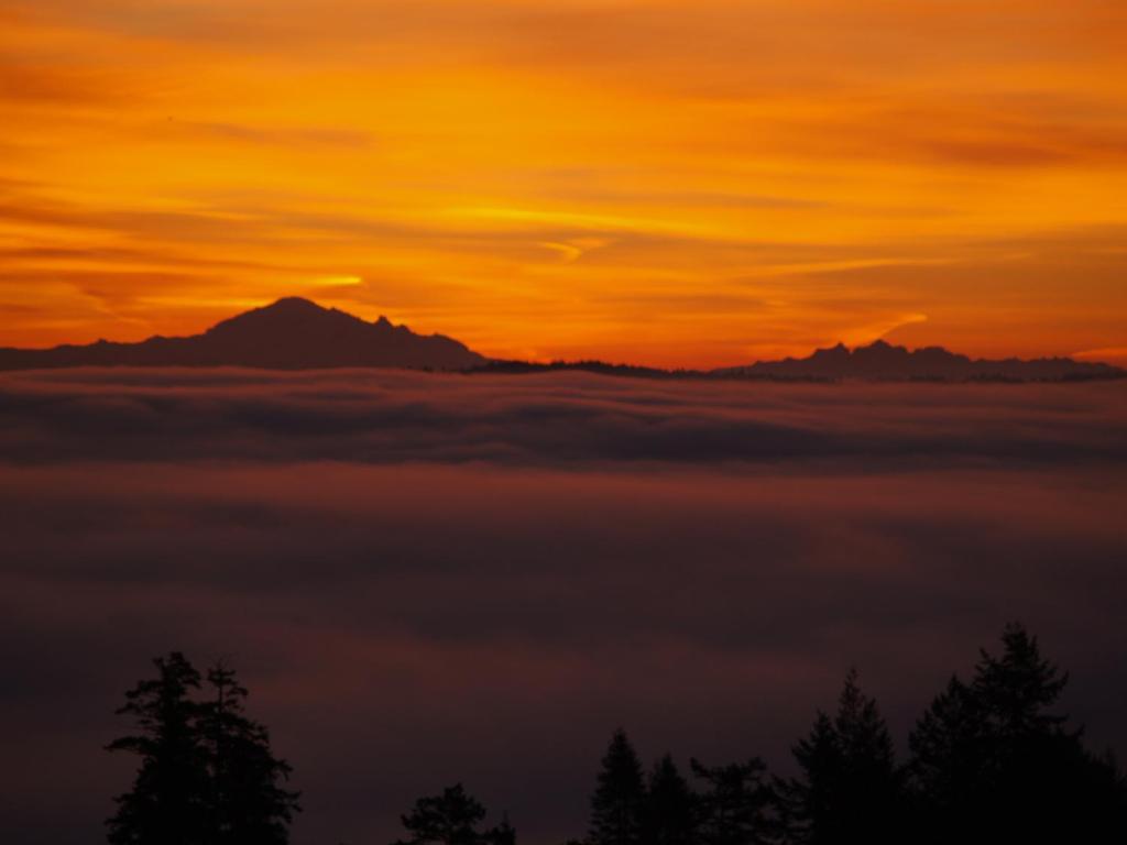 a view of the sunset with a layer of clouds at Gibralter Rock Ocean View B&B in Nanaimo