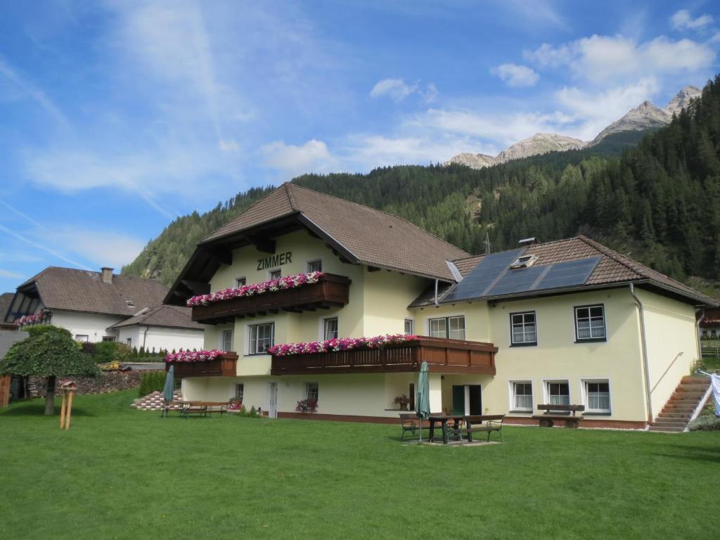 a large white building with flowers on the balcony at Gästehaus Marianne Baier in Zederhaus