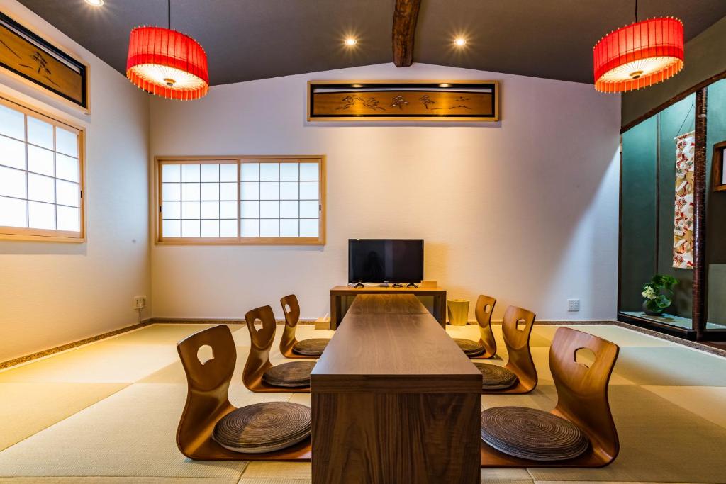 a room with a table and chairs and a tv at Bijou Suites Nagomi in Osaka