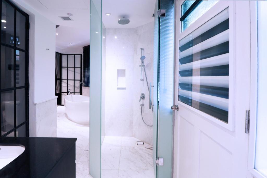 a bathroom with a shower and a sink and a toilet at Hotel NuVe Urbane in Singapore