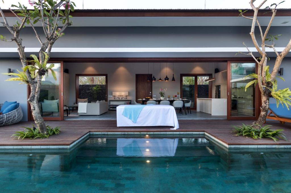 a villa with a pool and a dining area at Amarin Seminyak in Seminyak