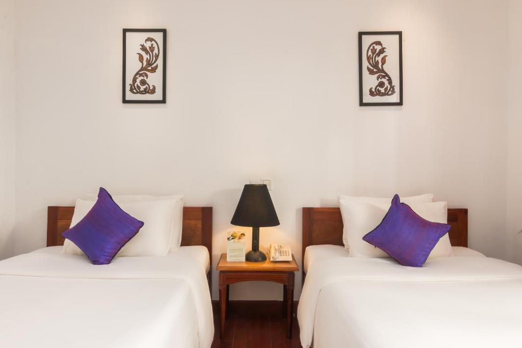 Postel nebo postele na pokoji v ubytování Apsara Centrepole Hotel
