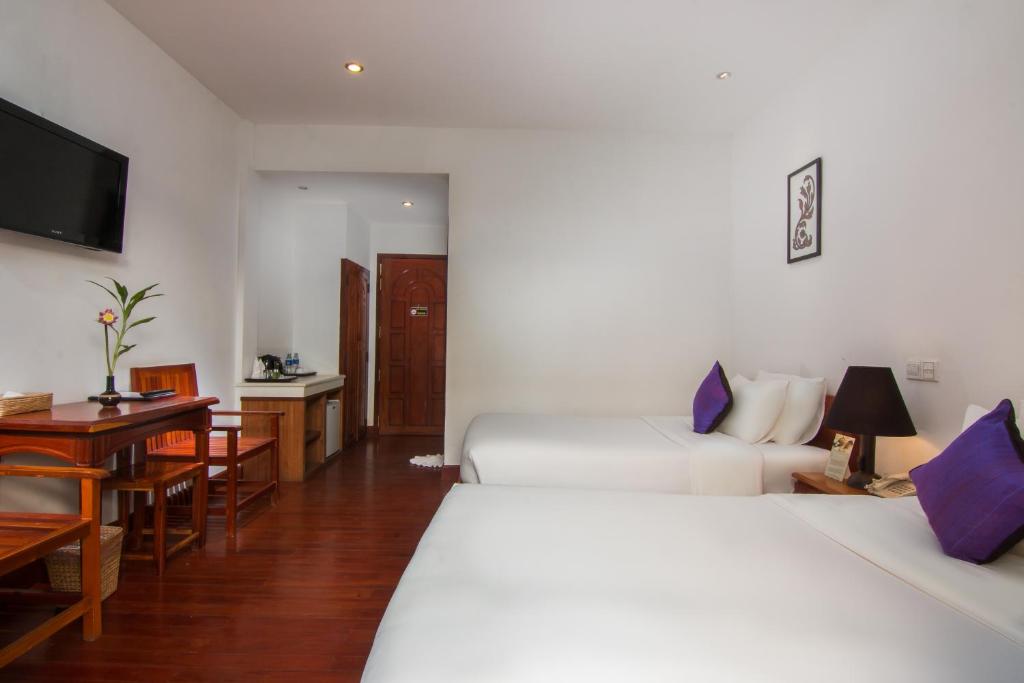 Postel nebo postele na pokoji v ubytování Apsara Centrepole Hotel