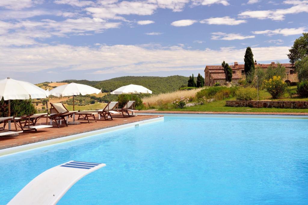 a large swimming pool with chairs and umbrellas at Agriturismo Zampugna in Montefollonico