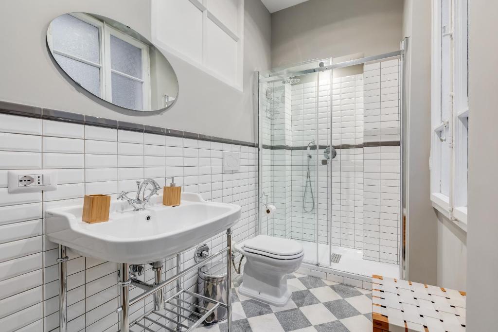 łazienka z umywalką, toaletą i lustrem w obiekcie Monti Colosseum apartment w Rzymie