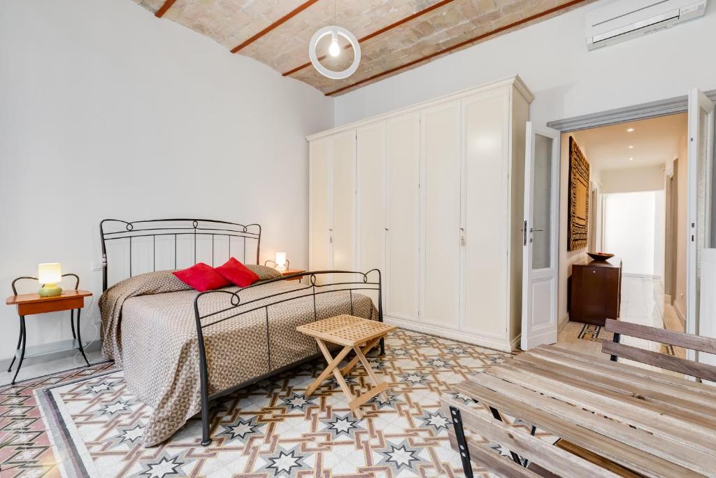 sypialnia z łóżkiem, stołem i ławką w obiekcie Monti Colosseum apartment w Rzymie