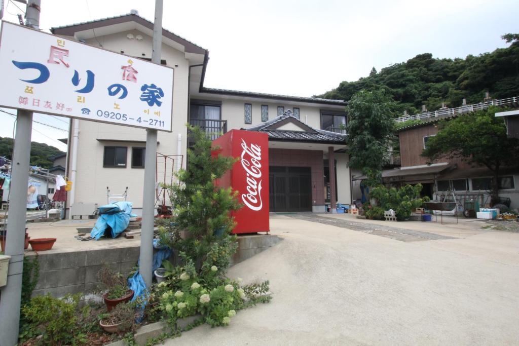 un panneau devant un bâtiment avec un arbre de Noël dans l'établissement Minshuku Tsurinoie, à Tsushima