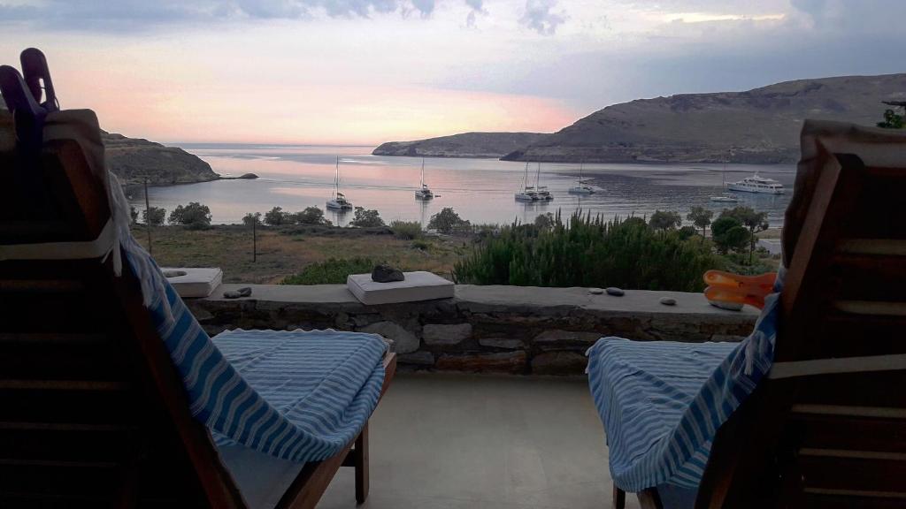 a balcony with two chairs and a view of the water at Serifos Dream Houses near the sea in Ganema