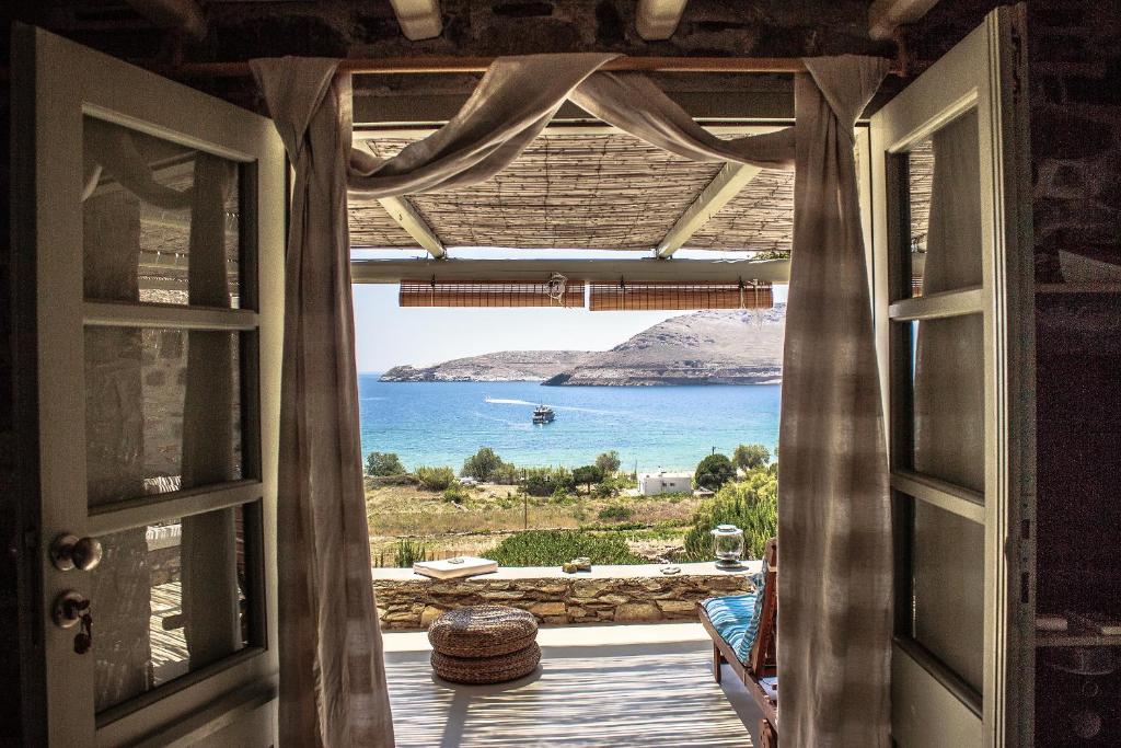 an open door to a view of the ocean from a house at Serifos Dream Houses near the sea in Ganema