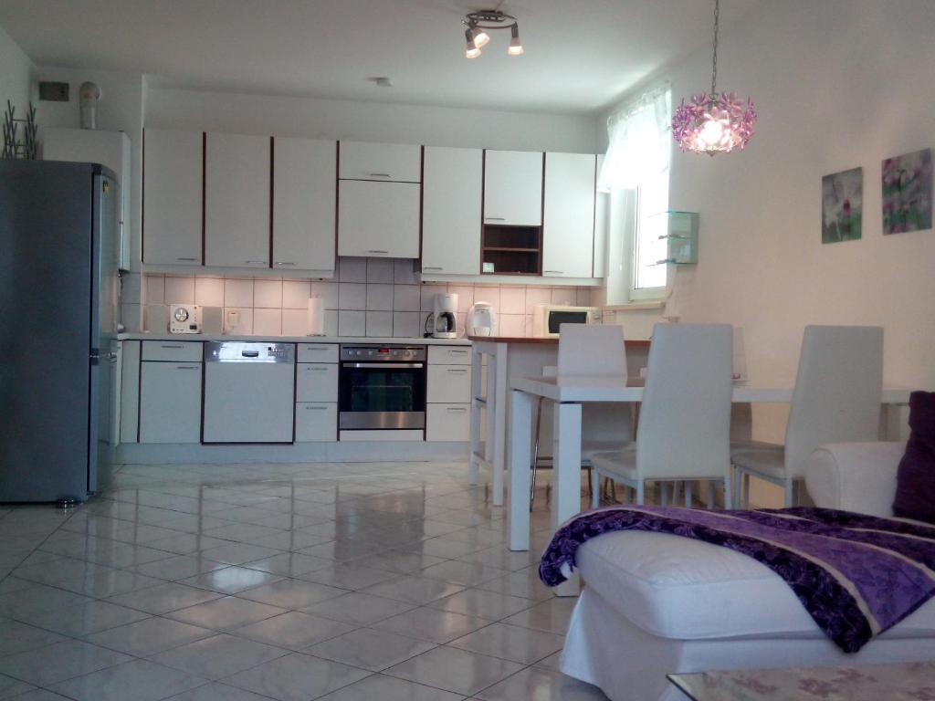 a kitchen with white cabinets and a table and chairs at Orchidee in Wiener Neudorf