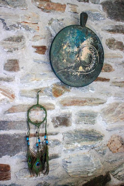 a pot and a basket hanging on a stone wall at Serifos Dream Houses near the sea in Ganema