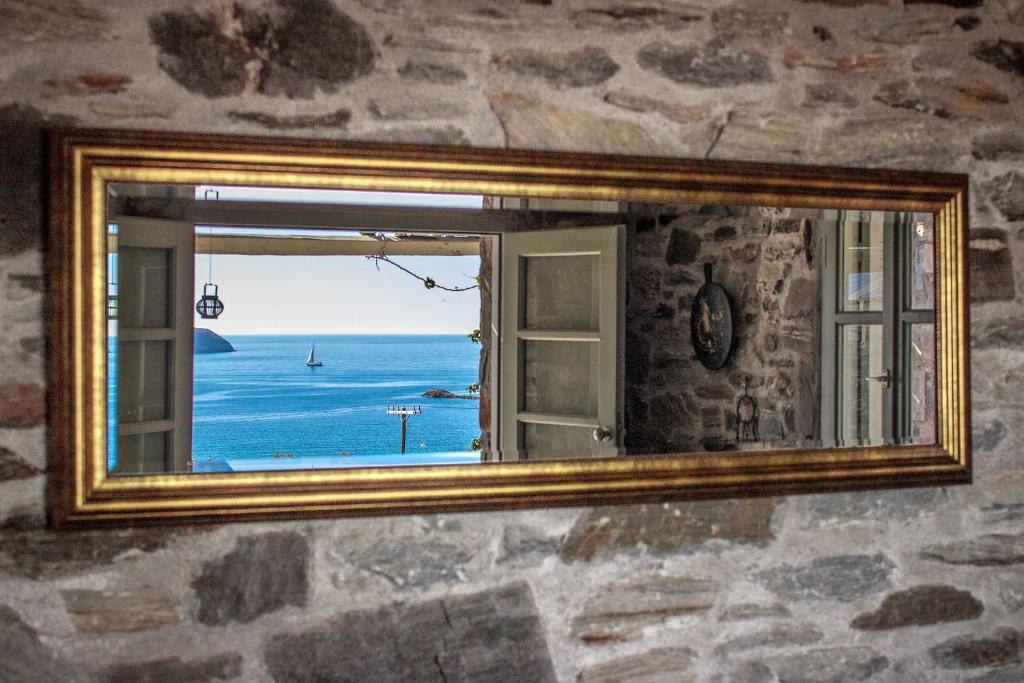 a mirror on a wall with a view of the ocean at Serifos Dream Houses near the sea in Ganema