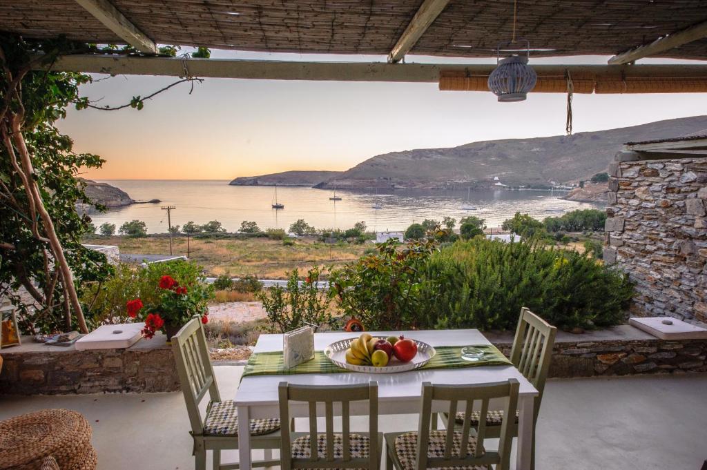 a table and chairs on a patio with a view of the ocean at Serifos Dream Houses near the sea in Ganema