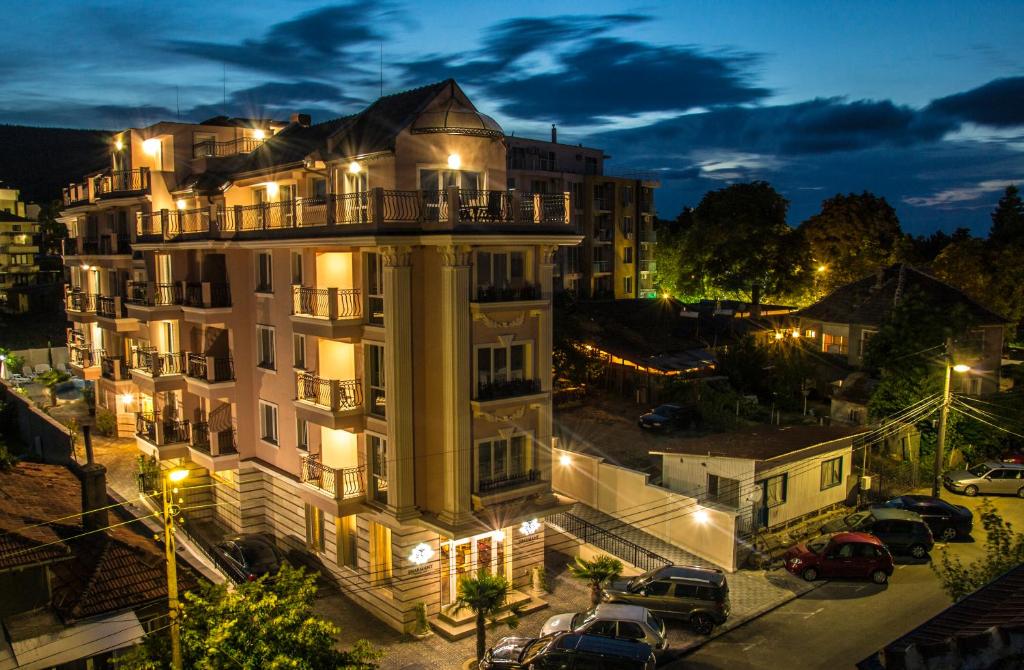 ein großes weißes Gebäude mit viel Licht in der Unterkunft Sirena Palace Family Hotel in Obsor