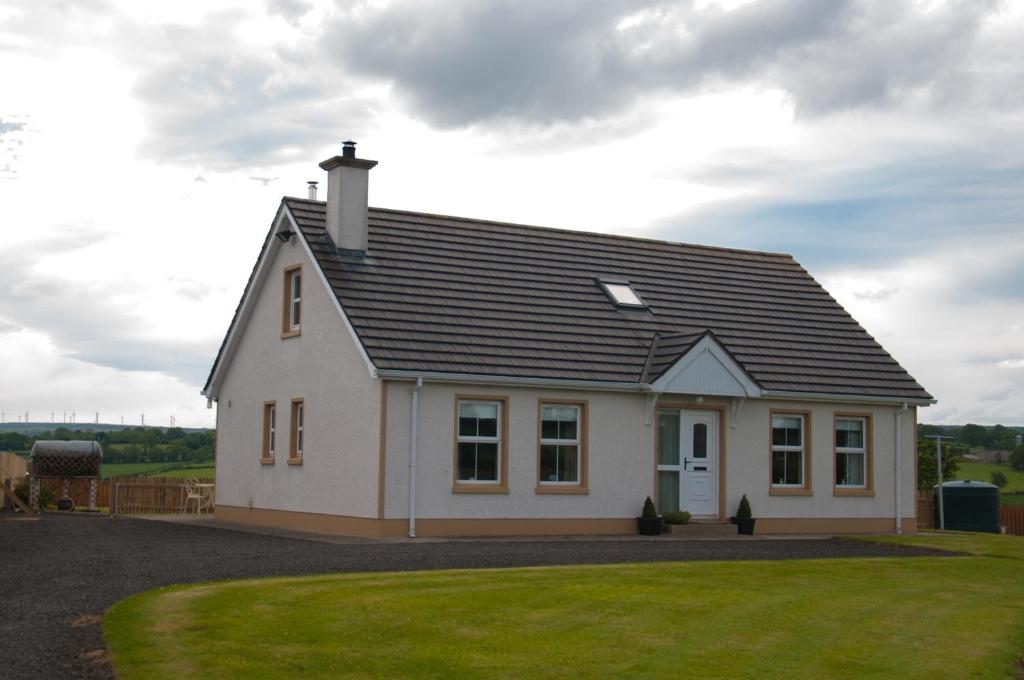 una casa bianca con tetto nero di Roe Valley Cottage - LA Spa Hot Tub a Limavady