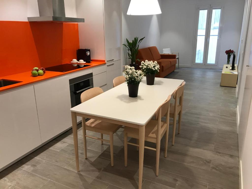 バルセロナにあるCosmo Apartments Marina – Auditoriのキッチン、ダイニングルーム(白いテーブル、椅子付)