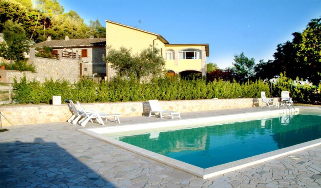 una piscina con sillas y una casa en el fondo en Belvedere Cramaccioli, en Vigne