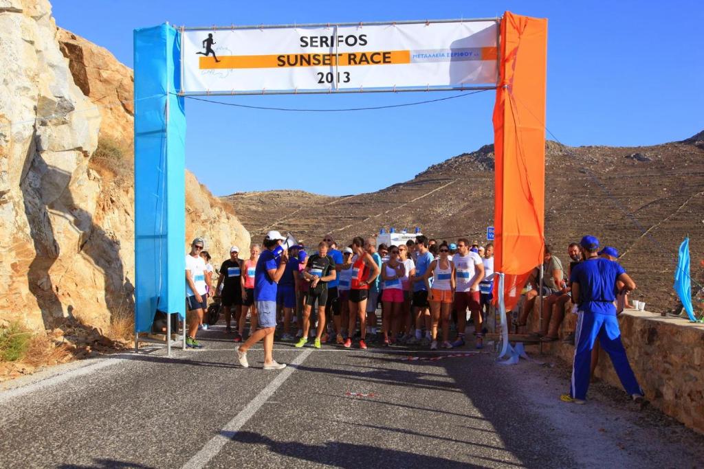 a group of people lined up at the start of a race at Serifos Dream Houses near the sea in Ganema