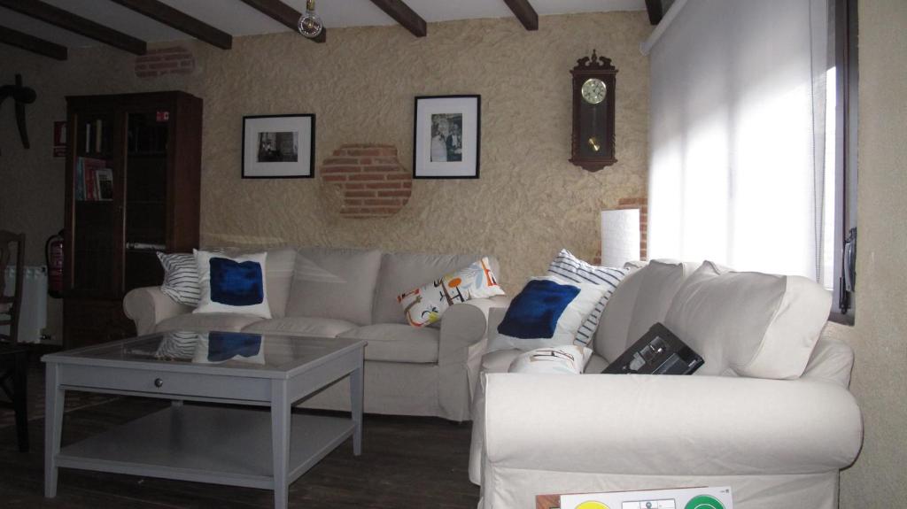 SueñoRural في San Miguel de Valero: غرفة معيشة مع أريكة بيضاء وطاولة