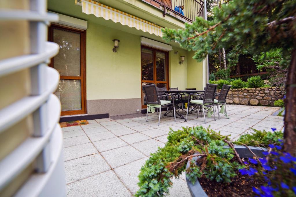a patio with a table and chairs in front of a building at Wonder Home - Apartamenty z balkonami przy szlakach turystycznych - blisko plac zabaw i boisko do gry in Karpacz