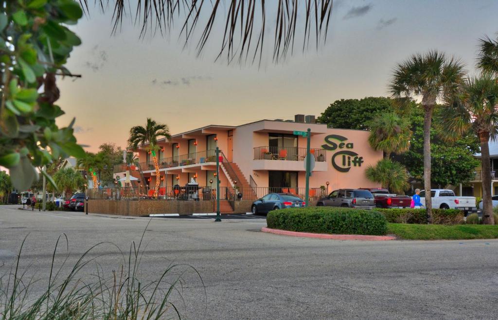 a building with cars parked in a parking lot at Sea Cliff Hotel in Fort Lauderdale