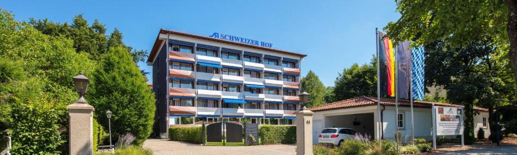 un bâtiment avec une voiture garée devant lui dans l'établissement Hotel Schweizer Hof Thermal und Vital Resort, à Bad Füssing