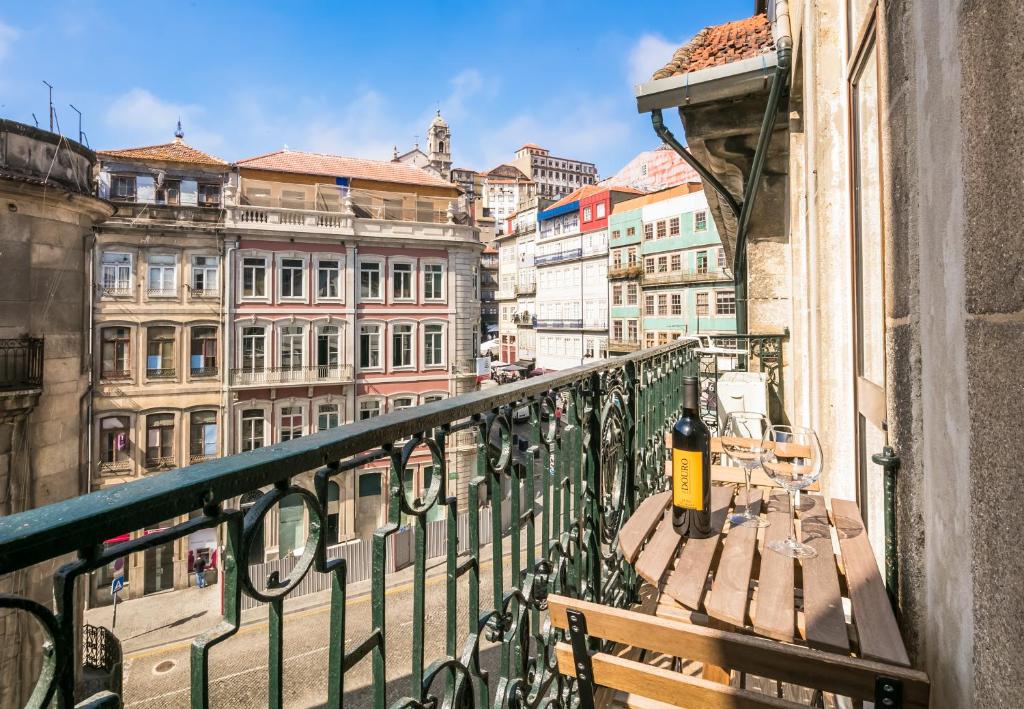 a bench on a balcony with a view of a city at Merc Porto Ribeira`s Place in Porto