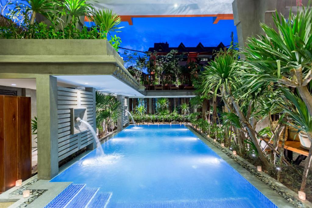 a swimming pool with a waterfall in the middle of a building at Golden Temple Boutique in Siem Reap