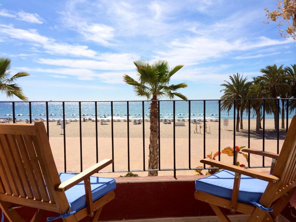 a balcony with two chairs and a view of the beach at The Old Fisherman´s House in Villajoyosa
