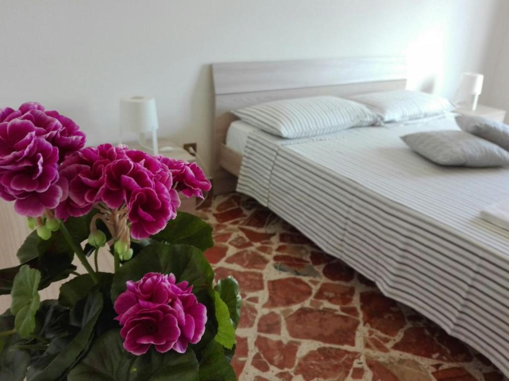 バゲリーアにあるCasa Vacanze DEMETRAのベッドルーム1室(ベッド1台、紫の花瓶付)