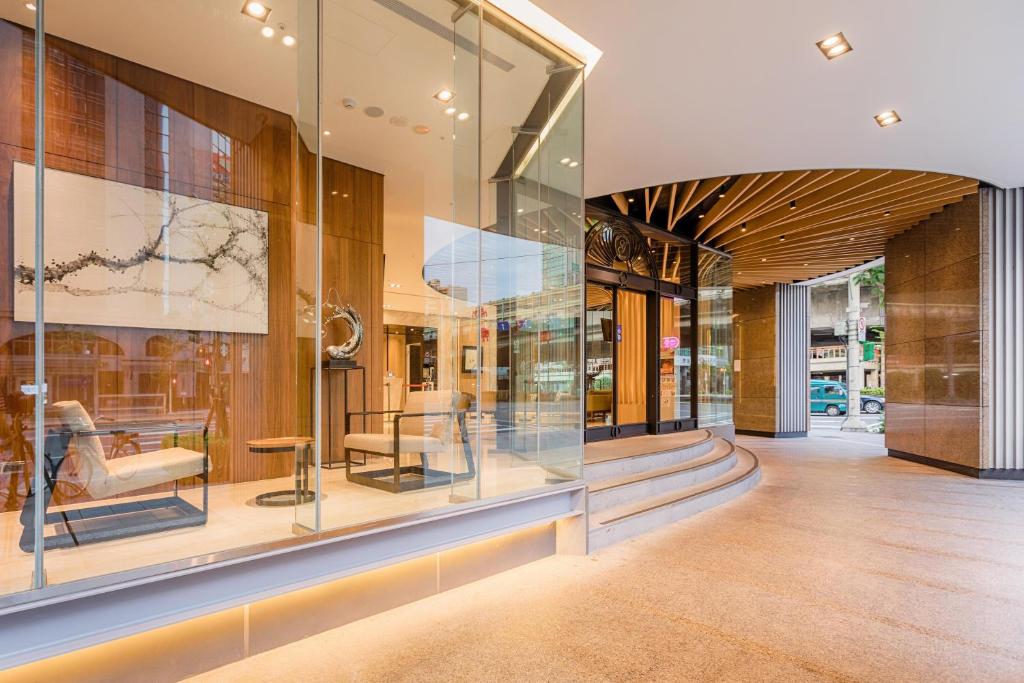 a lobby with glass windows and furniture on display at Green World Grand NanJing in Taipei