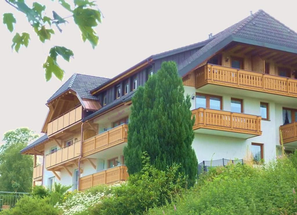 ein großes Gebäude mit einem Baum davor in der Unterkunft Hochtalblick in Bernau im Schwarzwald