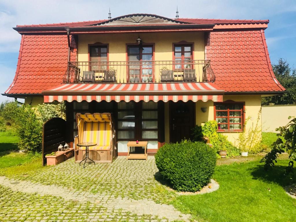 Casa con techo rojo y balcón en Green Field Apartments, en Kołobrzeg